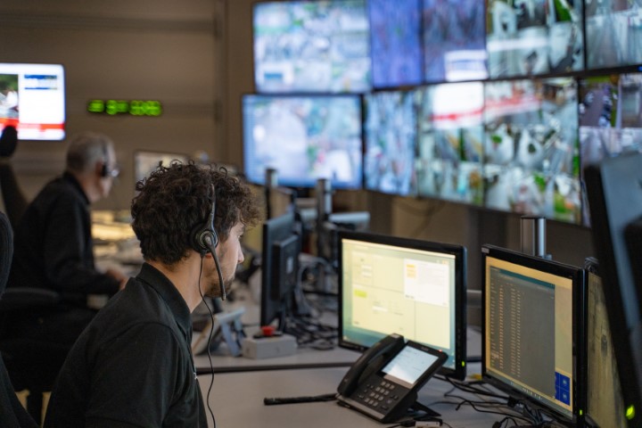 CCTV operators at a bank of monitors.